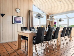 Ein Essbereich mit einem Holztisch, Stühlen, einer Uhr und einem gerahmten Bild an der Wand.