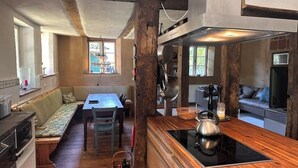 Una cucina con una panca di legno, un tavolo da pranzo e un piano cottura integrato.