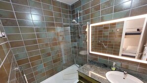 A bathroom with a shower, a sink, and a mirror. - Apartment on the 3rd floor, located right in the center of Font-Romeu (Font-Romeu-Odeillo-Via)