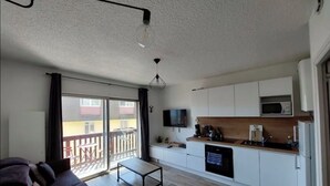 A modern apartment with a living room, kitchenette, and a balcony. - Apartment on the 3rd floor, located right in the center of Font-Romeu (Font-Romeu-Odeillo-Via)