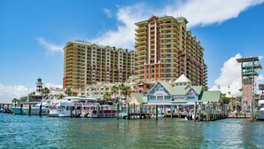 Ein Hotel am Wasser mit mehreren Hochhäusern, einer Marina mit Booten und einem Steg mit einem kleinen Gebäude mit der Aufschrift 'Waterwalk Marina'.