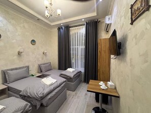Habitación triple estándar, vista a la ciudad | Escritorio, espacio para trabajar con laptop y insonorización 