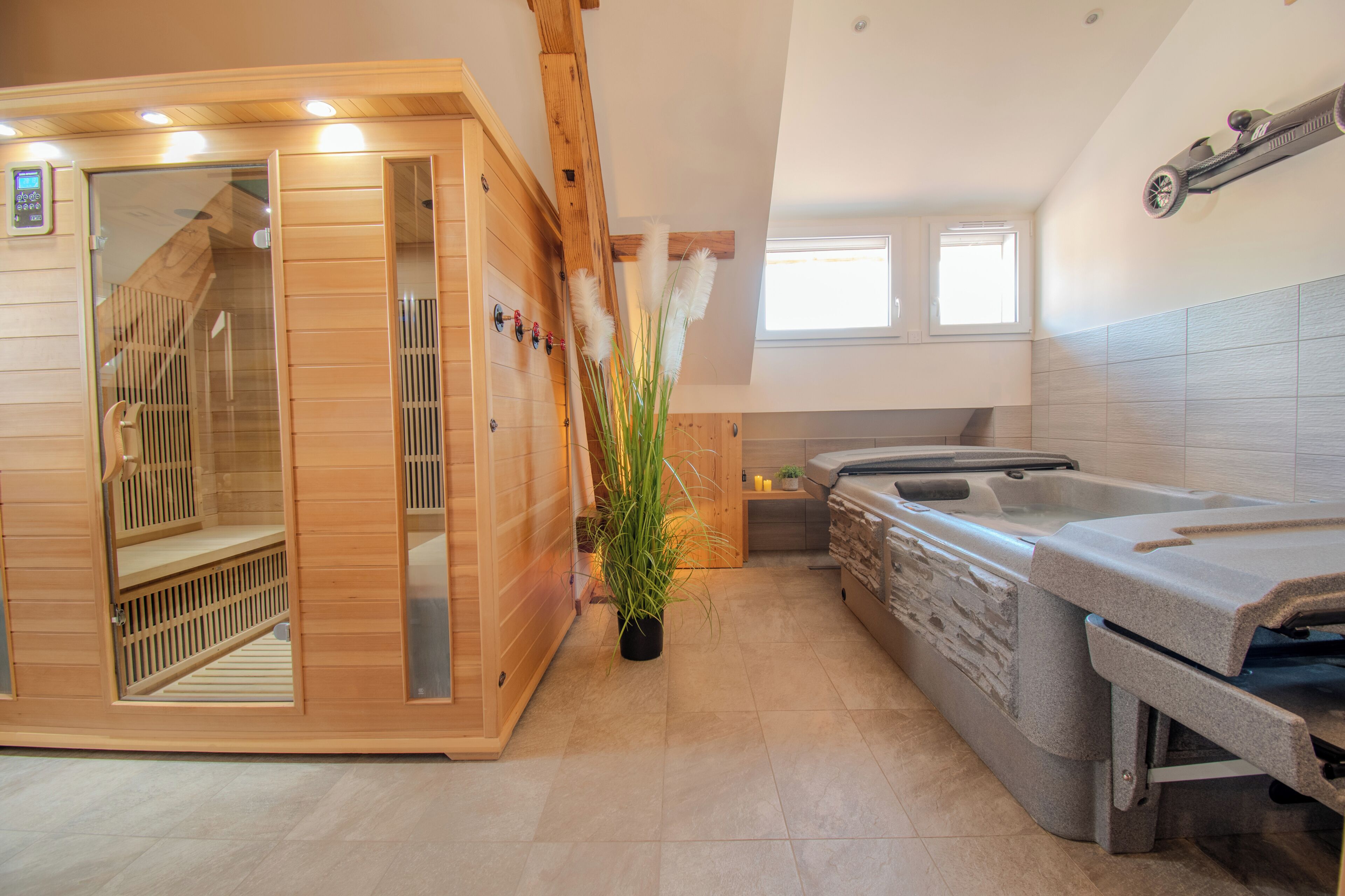 A sauna with a wooden interior, a stone hot tub, and a small kitchen area with a window.