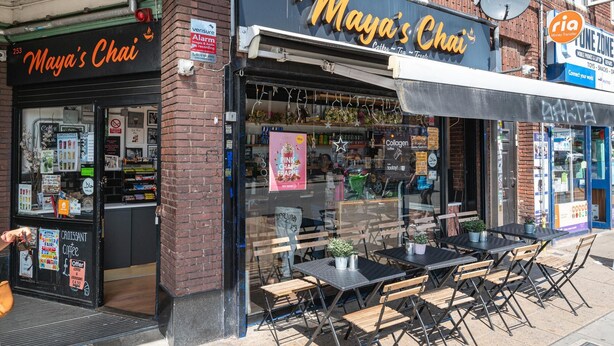 Una cafetería llamada 'Maya's Chai' con mesas al aire libre y una entrada visible.