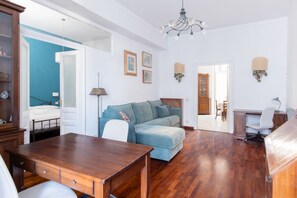 Ein geräumiges Wohnzimmer mit einem Holzessttisch, einer Couch und einem Schreibtisch.