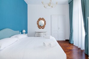 Ett hotellrum med en stor säng, en byrå, en spegel och en dörr.