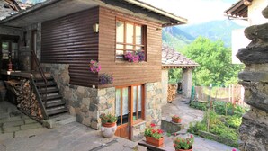A wooden cabin with a stone foundation, a wooden staircase, and a stone-paved courtyard with potted plants. - Baus's Cabins. A mountain cabin in the village—warm, cozy, and offering breathtaking views. (Turin)
