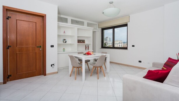 Ein modernes Wohnzimmer mit Essbereich, großem Fenster und Blick auf die Stadt.