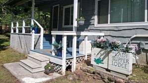 Uma casa com varanda, degraus e uma placa com a inscrição 'The Lady Slipper Lodge'.