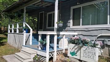 Uma casa com varanda, degraus e uma placa com a inscrição 'The Lady Slipper Lodge'.