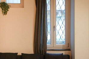 A room with a window, a plant, and a sofa. - Torino Centro | Saluzzo 17 Apartment (Torino)