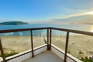 Uma varanda com vista para a praia e o mar.