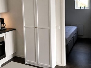 A room with a bed, a window with plants, and a kitchenette area. - 5 Star Holiday Home in Uddevalla (Uddevalla)