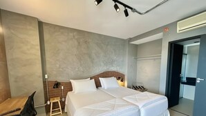 Una habitación de hotel moderna con una cama grande, un escritorio y una silla.