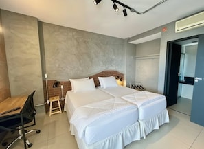 Una habitación de hotel moderna con una cama grande, un escritorio y una silla.