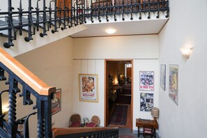 A staircase with a black railing and wooden steps, leading to an upper level. - Villa Borghese House (Rome)