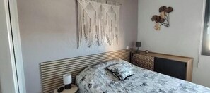 Ein Schlafzimmer mit Bett, Nachttisch, Lampe und Wanddekoration.