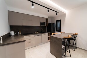 A modern kitchen with a central island, built-in appliances, and a dining area with bar stools. - Sunset 205 Luxury 1bd with gym (Tunis)