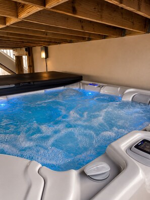 A hot tub with a control panel and a wooden ceiling structure. - Waterfront Lagoon Escape , Sunset Views, Private Dock and Minutes to LBI (Stafford Township)