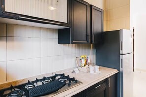 Eine Küche mit Gaskochfeld, Schränken und einem Kühlschrank.