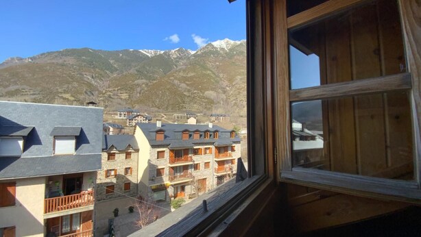 A mountain view with a building featuring balconies and a stone facade. - Benasque Shelter (Benasque)