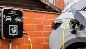 A hotel charging station with a brick wall background and a parked car connected to it. - 1 Person Holiday Park Home in Wulfsburg (Wolfsburg)