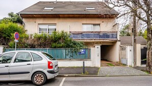 Ein Wohngebäude mit einer Garage, einem parkenden Auto und einem Verbotsschild.