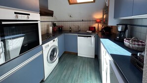 A compact kitchen with a built-in oven, a washing machine, and a dishwasher. - Apartment in Méribel, mountain view - 8 guests (Méribel)