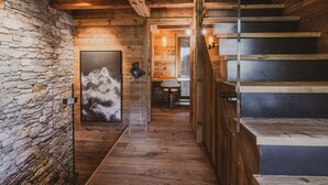 A wooden interior with a stone wall, a staircase, and a framed picture. - Chalet with Mont-Blanc view - 4 guests (Chamonix-Mont-Blanc)