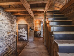 A wooden interior with a stone wall, a staircase, and a framed picture. - Chalet with Mont-Blanc view - 4 guests (Chamonix-Mont-Blanc)