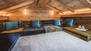 A cozy attic room with a wooden ceiling, a sofa set, and a small table with two teddy bears. - Chalet with Mont-Blanc view - 4 guests (Chamonix-Mont-Blanc)