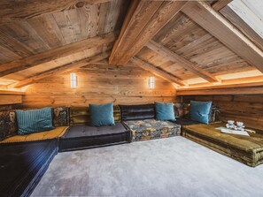 A cozy attic room with a wooden ceiling, a sofa set, and a small table with two teddy bears. - Chalet with Mont-Blanc view - 4 guests (Chamonix-Mont-Blanc)