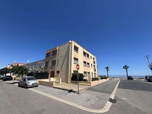 A multi-story building with a no entry sign, parked cars, and a clear blue sky. - Apartment sea view, AC - 4 guests (Port-la-Nouvelle)