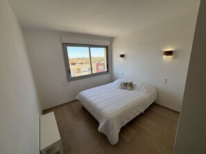 A bedroom with a single bed, a window, and two wall-mounted lights. - Apartment sea view, AC - 4 guests (Port-la-Nouvelle)