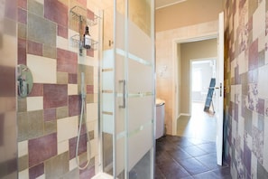 A bathroom with a shower, tiled walls, and a glass door. - Torino Centro | Casa Regina (Torino)