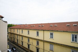 A multi-story building with a red-tiled roof and multiple windows. - Torino Centro | Casa Regina (Torino)