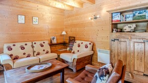 Un interior de madera con un sofá, una mesa de centro y un sillón de cuero.