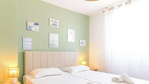 Ein Hotelzimmer mit einem Bett, zwei Nachttischlampen und Wandbildern.