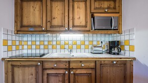 Una cucina con mobili in legno, un forno a microonde, un tostapane e una macchina da caffè.