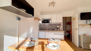 A compact kitchen with a microwave, coffee maker, and a tiled backsplash. - Bright studio, ski-in/ski-out - 4 guests (Les Menuires)