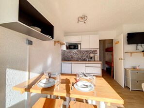 A compact kitchen with a microwave, coffee maker, and a tiled backsplash. - Bright studio, ski-in/ski-out - 4 guests (Les Menuires)
