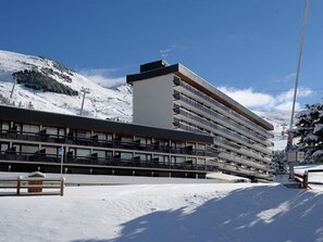 A multi-story hotel with a modern architectural design, featuring balconies and large windows. - Bright studio, ski-in/ski-out - 4 guests (Les Menuires)