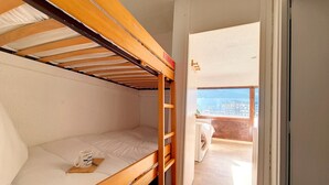 A bunk bed room with a window leading to a balcony. - Bright studio, ski-in/ski-out - 4 guests (Les Menuires)