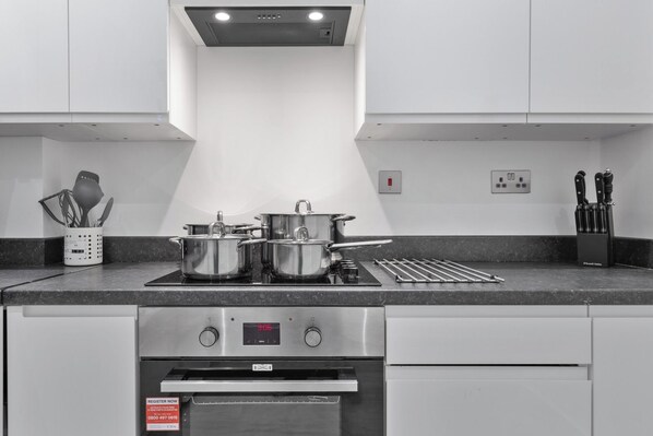 A modern kitchen with stainless steel appliances, including a stove, oven, and a range hood.