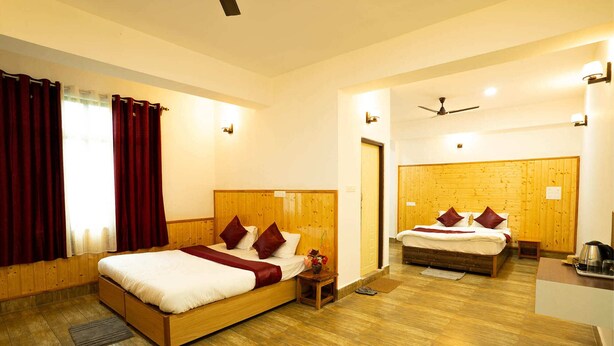 A hotel room with two beds, wooden flooring, and a wooden headboard. - Twin Garden by TAPSOM (Gangtok)