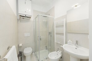 A modern bathroom with a glass-enclosed shower, a toilet, a sink, and a towel rack. - Torino Regio Parco | Mantova House 1 (Torino)