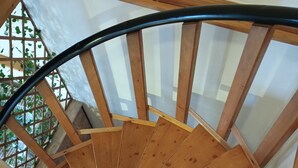 Eine Wendeltreppe aus Holz mit Glastrennwand.