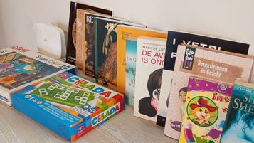 A collection of books and a puzzle on a wooden surface.
