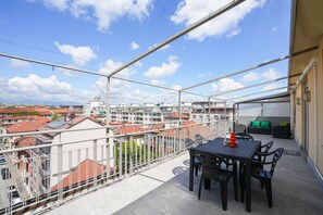 A balcony with a table and chairs, a railing, and a view of buildings. - Torino Centro | Casa Matilda (Torino)