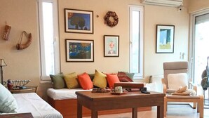 Una sala de estar con un sofá, una mesa de centro, una silla y un radiador.